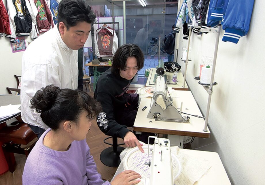 ドブ板コーバスタジオで横振り刺繍の練習生を指導する山上大輔さん